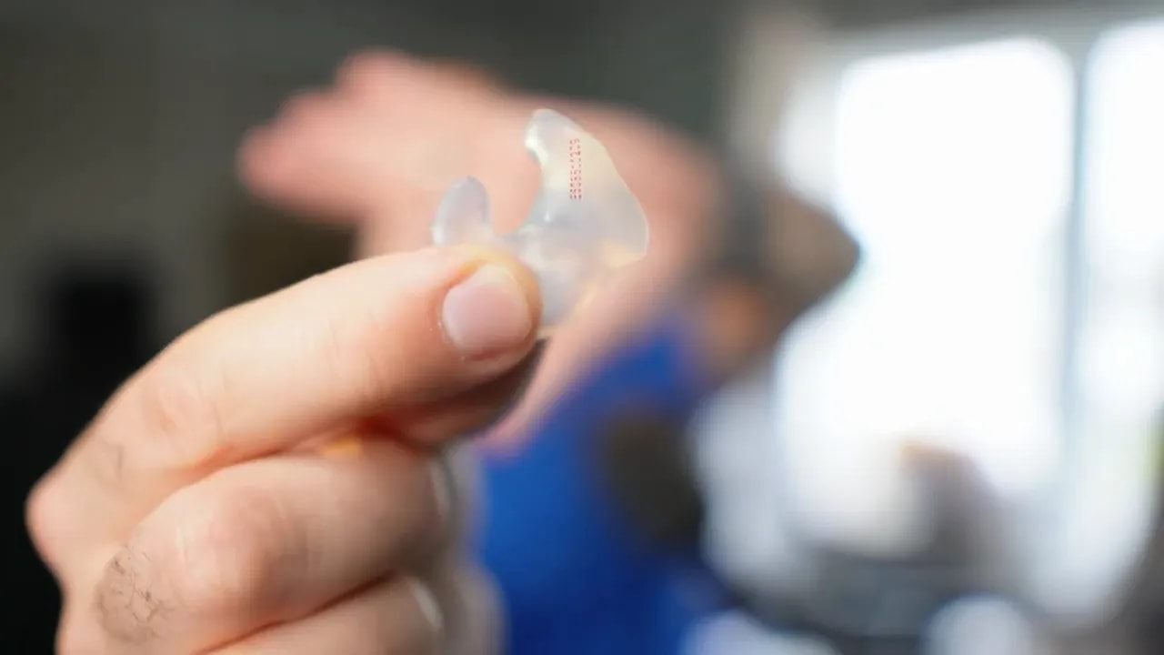 Clear custom molded earplug held close to the camera